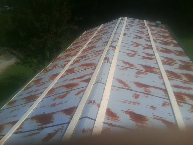 Rusted metal roof panels with new wood purlins before replacement — Storm Damage Roof Repair in Lawrence by Roofing Brothers